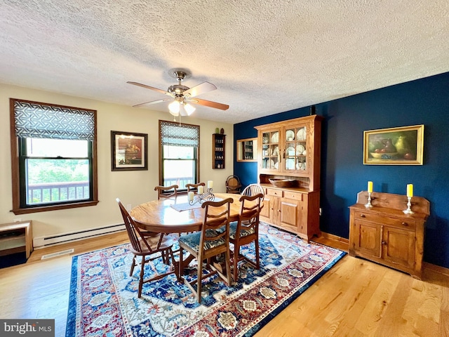 299 Valentine Acres Rd, Clearville, PA 15535 - dining space featuring baseboard heating, light wood finished floors, a textured ceiling, ceiling fan, and baseboards