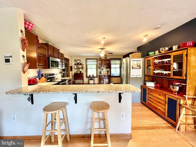 299 Valentine Acres Rd, Clearville, PA 15535 - kitchen featuring appliances with stainless steel finishes, a textured ceiling, ceiling fan, a peninsula, and light wood-style flooring