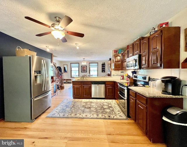 299 Valentine Acres Rd, Clearville, PA 15535 - kitchen featuring appliances with stainless steel finishes, a peninsula, a textured ceiling, light wood-style floors, and a ceiling fan