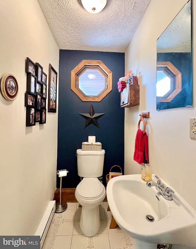 299 Valentine Acres Rd, Clearville, PA 15535 - bathroom featuring a sink, toilet, a baseboard heating unit, a textured ceiling, and tile patterned floors