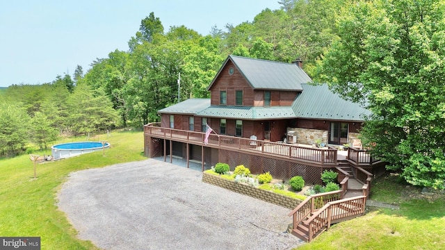 299 Valentine Acres Rd, Clearville, PA 15535 - rear view of property featuring driveway, a lawn, a wooden deck, and an attached garage