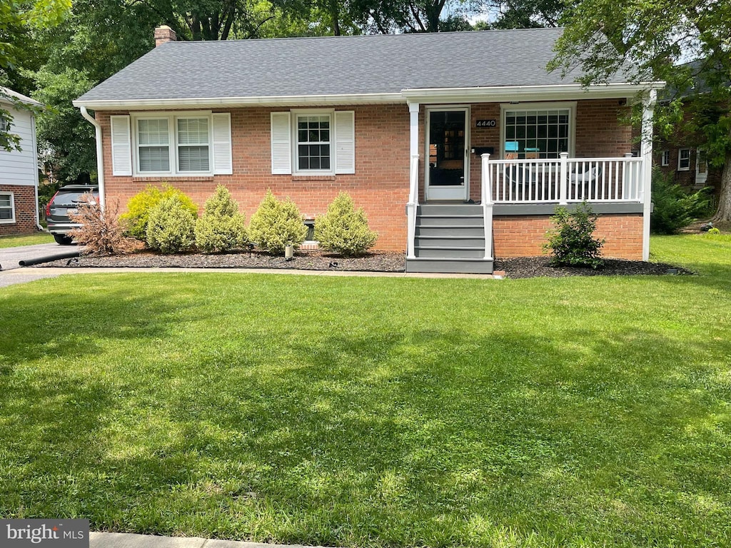 4440 Wells Pkwy, Hyattsville, MD 20782 - view of front of house with covered porch, brick siding, a front lawn, and a chimney