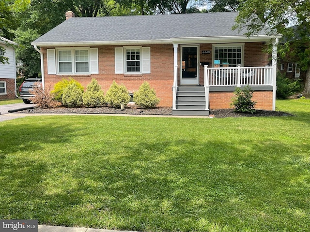4440 Wells Pkwy, Hyattsville, MD 20782 - view of front of house with covered porch, brick siding, a front lawn, and a chimney