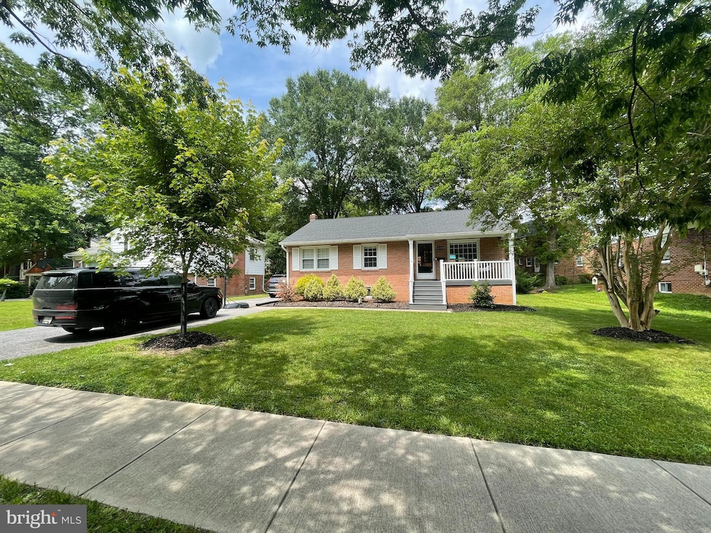 4440 Wells Pkwy, Hyattsville, MD 20782 - ranch-style house with a porch, a front yard, brick siding, and a chimney