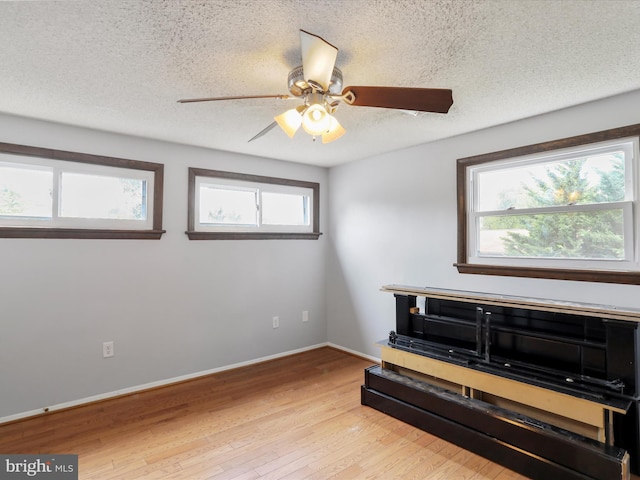 11815 Oriole Dr, Hagerstown, MD 21742 - living area featuring light wood-style flooring, a textured ceiling, a ceiling fan, and baseboards