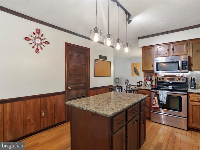 11815 Oriole Dr, Hagerstown, MD 21742 - kitchen featuring stainless steel appliances, wainscoting, light wood-style floors, a textured ceiling, and a kitchen island