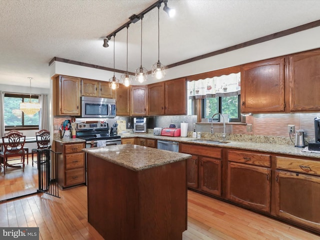 11815 Oriole Dr, Hagerstown, MD 21742 - kitchen with appliances with stainless steel finishes, a sink, light wood finished floors, a kitchen island, and hanging light fixtures