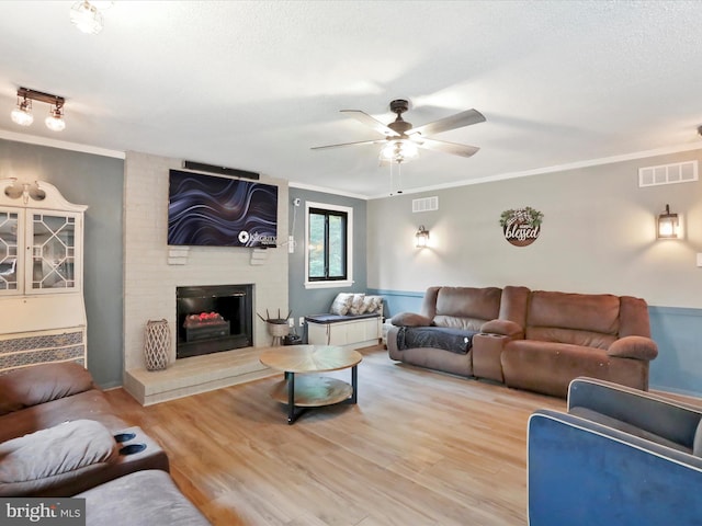 11815 Oriole Dr, Hagerstown, MD 21742 - living room with a ceiling fan, ornamental molding, wood finished floors, a fireplace, and a textured ceiling