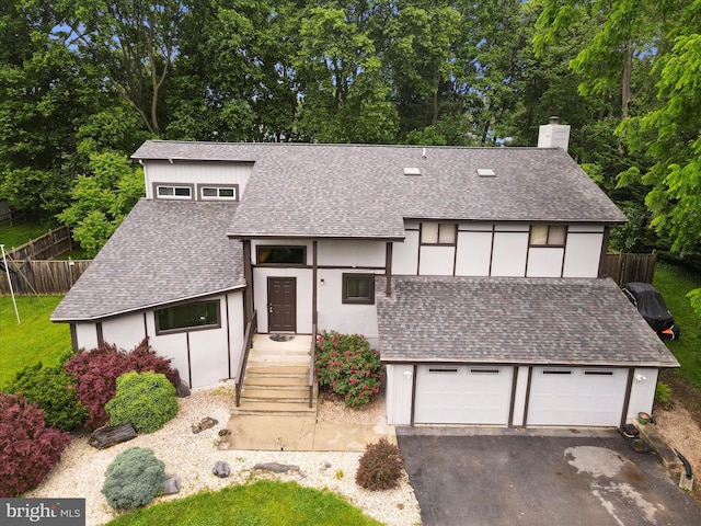 11815 Oriole Dr, Hagerstown, MD 21742 - view of front of house with roof with shingles, a chimney, asphalt driveway, stucco siding, and view of wooded area