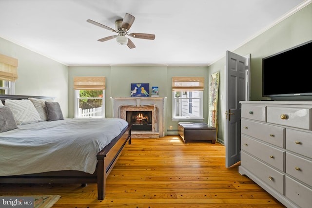 65 Covered Bridge Rd, New Hope, PA 18938 - bedroom with ornamental molding, light wood-type flooring, a warm lit fireplace, baseboard heating, and ceiling fan