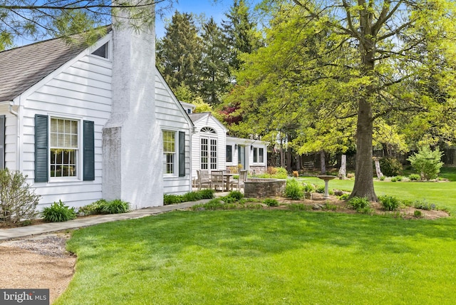 65 Covered Bridge Rd, New Hope, PA 18938 - view of property exterior with a yard, a chimney, a patio area, and a shingled roof
