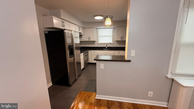 2126 E Sanger St, Philadelphia, PA 19124 - kitchen featuring stainless steel appliances, dark countertops, decorative backsplash, pendant lighting, and white cabinets