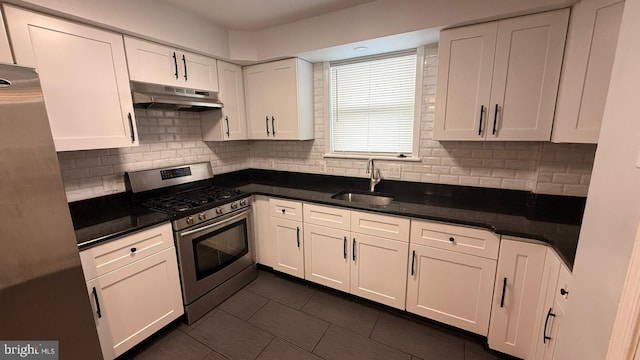 2126 E Sanger St, Philadelphia, PA 19124 - kitchen with appliances with stainless steel finishes, under cabinet range hood, white cabinetry, dark countertops, and backsplash