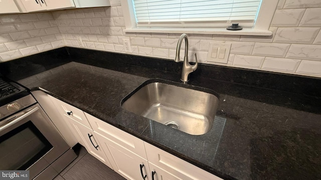 2126 E Sanger St, Philadelphia, PA 19124 - kitchen with white cabinetry, backsplash, dark stone counters, and stainless steel range oven