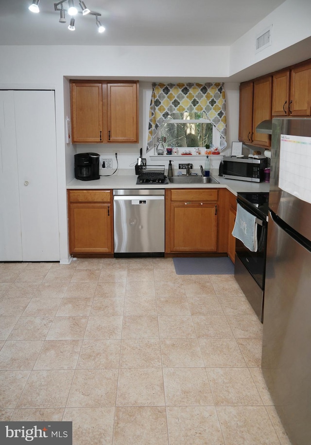 9 Wyndham Ct, Downingtown, PA 19335 - kitchen featuring appliances with stainless steel finishes, a sink, range hood, light countertops, and brown cabinetry