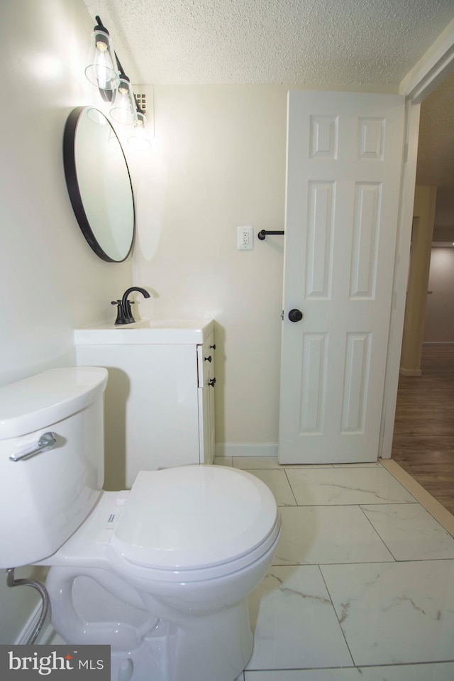 2030 N Adams St Unit 509, Arlington, VA 22201 - half bath featuring toilet, a textured ceiling, marble look tiles, baseboards, and vanity