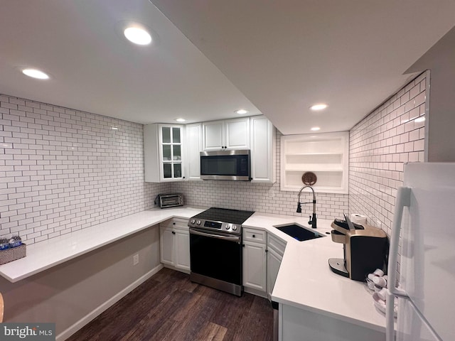 1319 Remington Rd, Wynnewood, PA 19096 - kitchen featuring appliances with stainless steel finishes, a sink, tasteful backsplash, dark wood-type flooring, and light countertops