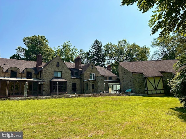 1319 Remington Rd, Wynnewood, PA 19096 - rear view of house with a lawn, stone siding, and a chimney