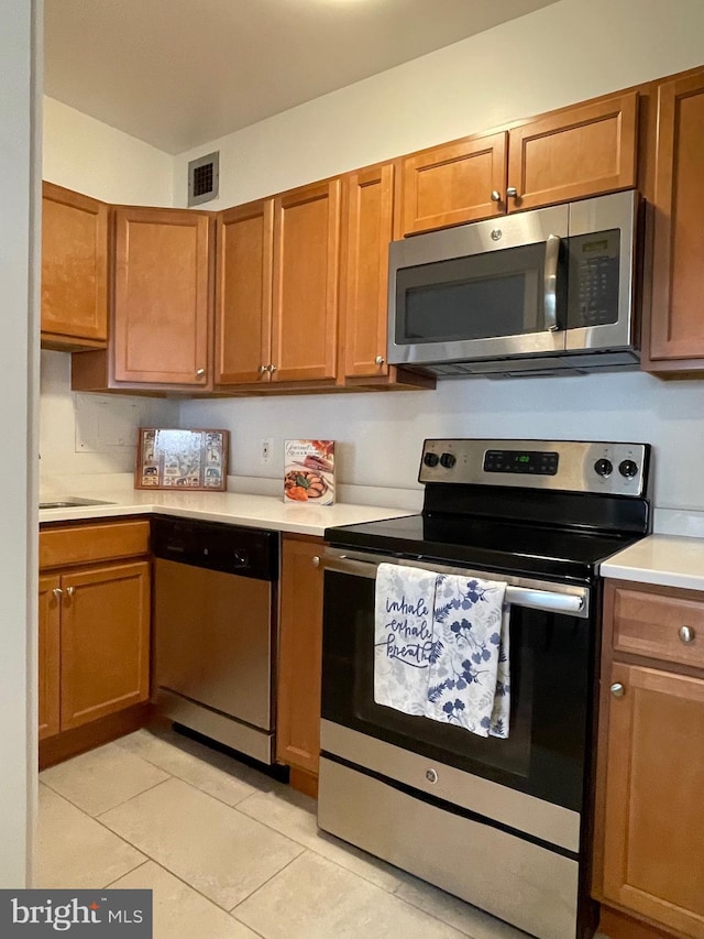 510 N Street Street SW Unit N223, Washington, DC 20024 - kitchen with appliances with stainless steel finishes, light countertops, light tile patterned flooring, and brown cabinetry