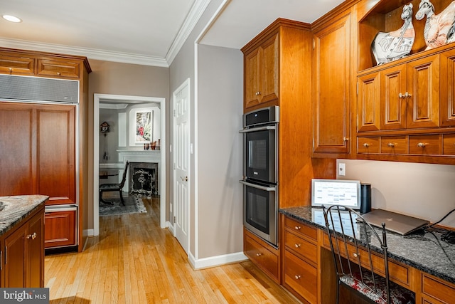 1217 Tullamore Cir, Chester Springs, PA 19425 - kitchen featuring paneled fridge, stainless steel double oven, light wood-style flooring, brown cabinets, and crown molding