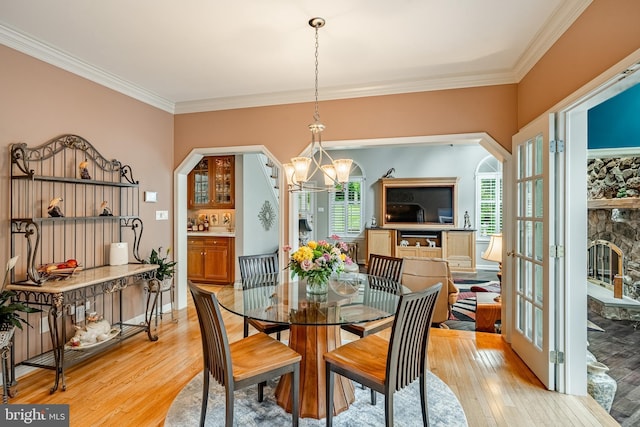 1217 Tullamore Cir, Chester Springs, PA 19425 - dining room featuring ornamental molding, light wood finished floors, a chandelier, and a stone fireplace