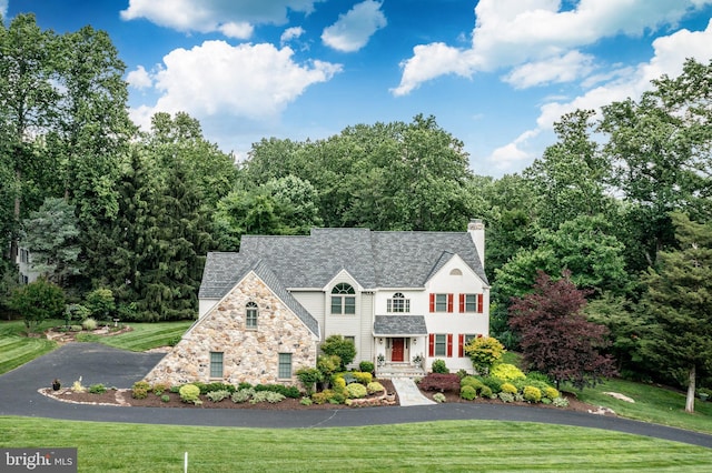 1217 Tullamore Cir, Chester Springs, PA 19425 - view of front of house with stone siding, a front lawn, a chimney, and driveway