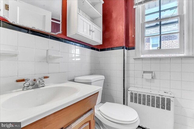 1240 Harding Dr, Havertown, PA 19083 - half bath featuring radiator, tile walls, vanity, and tasteful backsplash
