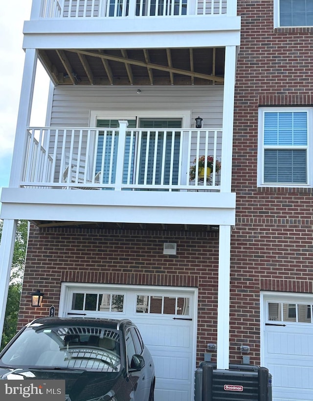 9402 James Macgowan Ln Unit 611, Owings Mills, MD 21117 - view of side of home with a balcony, a garage, brick siding, and cooling unit