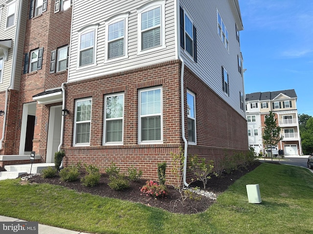 9402 James Macgowan Ln Unit 611, Owings Mills, MD 21117 - view of home's exterior with brick siding and a yard
