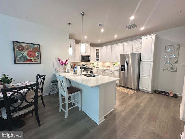 9402 James Macgowan Ln Unit 611, Owings Mills, MD 21117 - kitchen with stainless steel appliances, a peninsula, glass insert cabinets, a kitchen bar, and wood finished floors