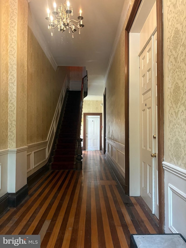 1313 Eutaw Pl, Baltimore, MD 21217 - staircase with hardwood / wood-style flooring, wallpapered walls, a chandelier, a decorative wall, and crown molding