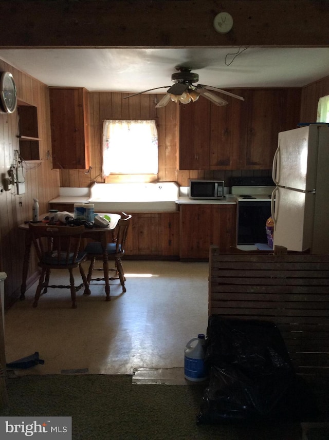 529 Oldtown Rd, Goldsboro, MD 21636 - kitchen featuring white appliances, wood walls, a ceiling fan, and brown cabinetry