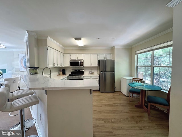 6820 Jade Ct, Capitol Heights, MD 20743 - kitchen with stainless steel appliances, a peninsula, light wood finished floors, backsplash, and ornamental molding