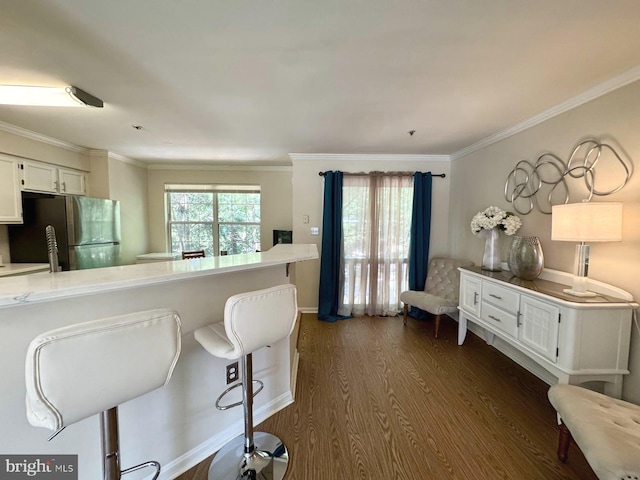 6820 Jade Ct, Capitol Heights, MD 20743 - kitchen with freestanding refrigerator, dark wood-type flooring, a kitchen breakfast bar, white cabinetry, and light countertops
