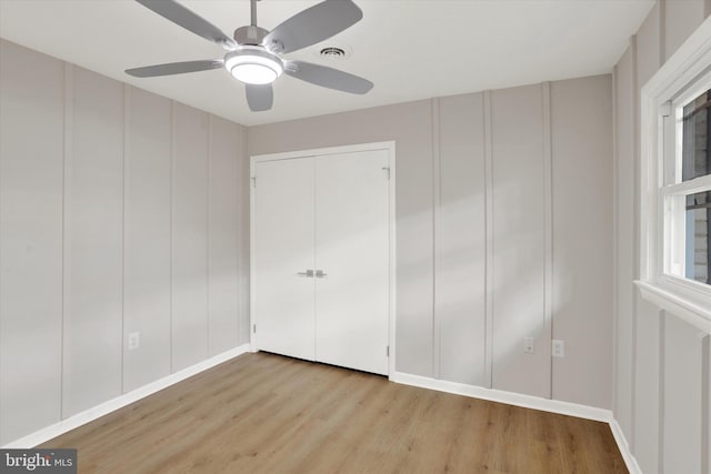 1216 Steamboat Rd, Shady Side, MD 20764 - unfurnished bedroom with a decorative wall, wood finished floors, a ceiling fan, and a closet