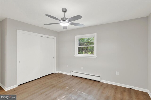 1216 Steamboat Rd, Shady Side, MD 20764 - unfurnished bedroom featuring a baseboard heating unit, wood finished floors, a closet, and a ceiling fan