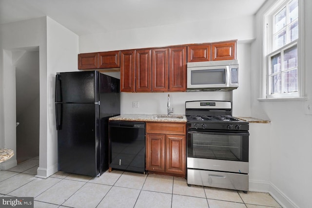 212 Division Ave NE, Washington, DC 20019 - kitchen with black appliances, a sink, light tile patterned floors, and baseboards