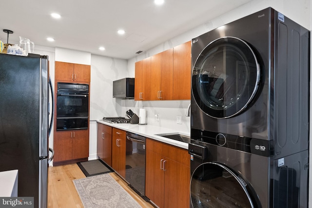2700 Virginia Ave NW Unit 109, Washington, DC 20037 - kitchen with freestanding refrigerator, stacked washing machine and dryer, black oven, dishwashing machine, and a warming drawer