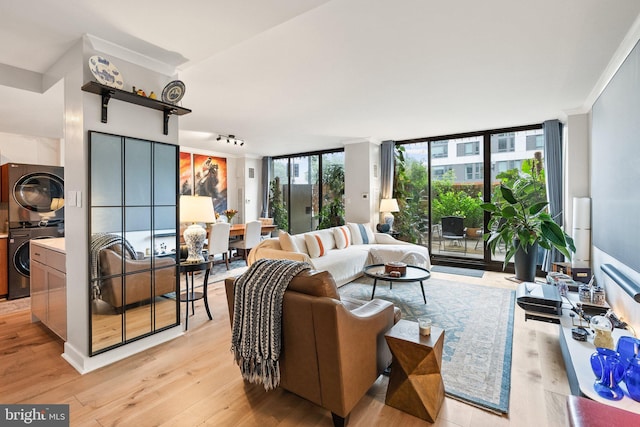 2700 Virginia Ave NW Unit 109, Washington, DC 20037 - living area featuring stacked washer / drying machine, expansive windows, and light wood-style floors