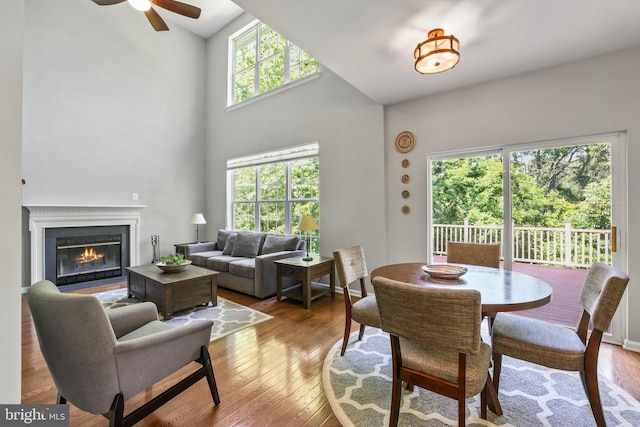 17542 Falls Pl, Round Hill, VA 20141 - dining space with a ceiling fan, wood-type flooring, a fireplace with flush hearth, and high vaulted ceiling