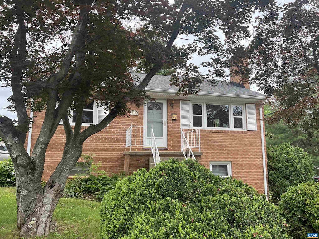 819 Elliott Ave, Charlottesville, VA 22902 - view of front of home featuring a chimney, brick siding, and roof with shingles