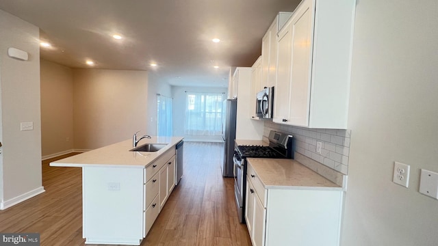 4904 Brookside Ct, Coopersburg, PA 18036 - kitchen with appliances with stainless steel finishes, a sink, a kitchen island with sink, backsplash, and light wood finished floors