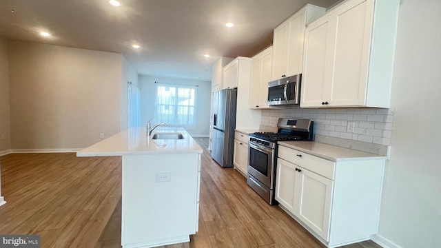 4904 Brookside Ct, Coopersburg, PA 18036 - kitchen with stainless steel appliances, a sink, a kitchen island with sink, decorative backsplash, and white cabinets