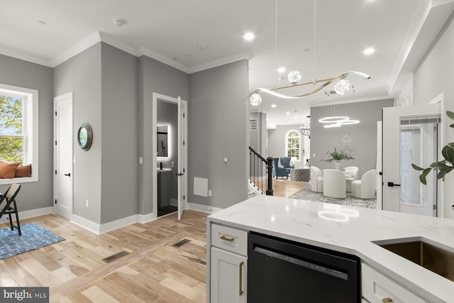 11921 Coronada Pl, Kensington, MD 20895 - kitchen with black dishwasher, ornamental molding, light stone countertops, light wood finished floors, and a chandelier