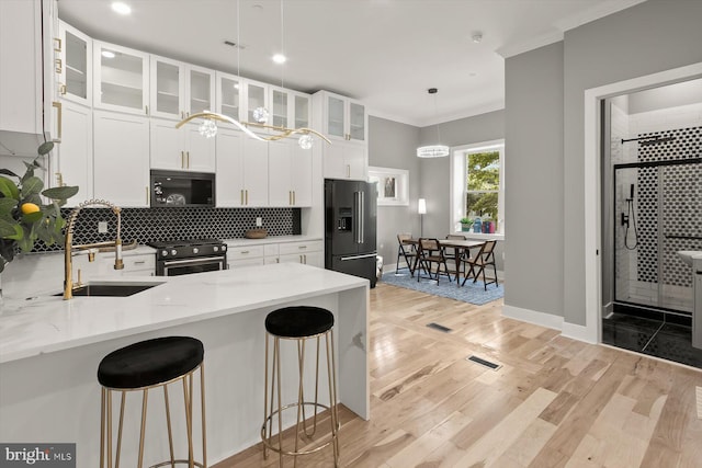 11921 Coronada Pl, Kensington, MD 20895 - kitchen featuring high quality fridge, range with gas stovetop, a sink, a kitchen breakfast bar, and crown molding