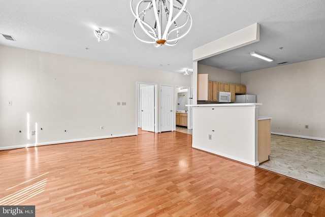 7432 Hindon Cir Unit B1-204, Windsor Mill, MD 21244 - unfurnished living room with a chandelier and light wood-type flooring