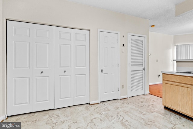 7432 Hindon Cir Unit B1-204, Windsor Mill, MD 21244 - kitchen featuring light brown cabinets, a textured ceiling, and light countertops