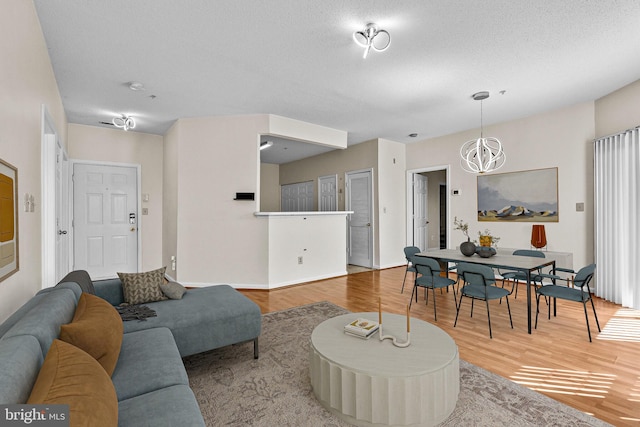 7432 Hindon Cir Unit B1-204, Windsor Mill, MD 21244 - living area featuring wood finished floors, a chandelier, and a textured ceiling