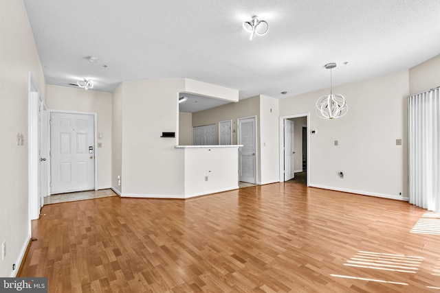 7432 Hindon Cir Unit B1-204, Windsor Mill, MD 21244 - unfurnished living room with a chandelier and light wood finished floors