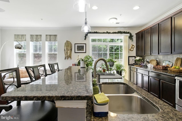 135 Jacobia Dr Unit H-3, Pasadena, MD 21122 - kitchen with plenty of natural light, ornamental molding, decorative light fixtures, a kitchen bar, and dark stone countertops